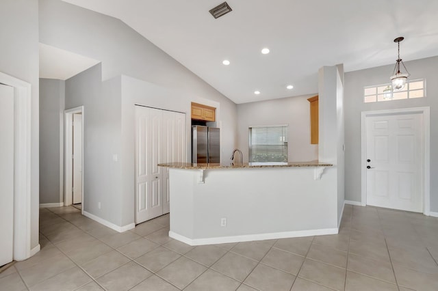 kitchen with stainless steel refrigerator, sink, hanging light fixtures, kitchen peninsula, and lofted ceiling