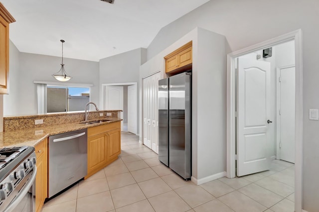 kitchen featuring appliances with stainless steel finishes, light stone counters, sink, light tile patterned floors, and pendant lighting