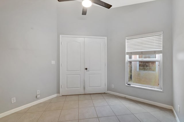 unfurnished bedroom featuring light tile patterned floors, a closet, and ceiling fan