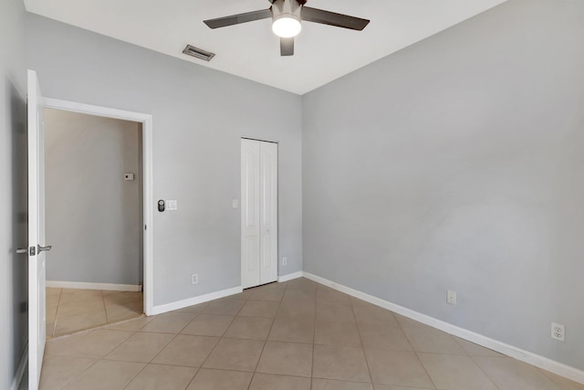 tiled spare room with ceiling fan