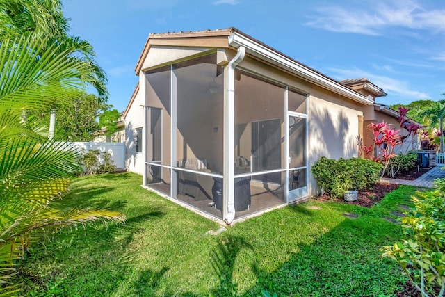 view of side of property featuring a sunroom and a yard