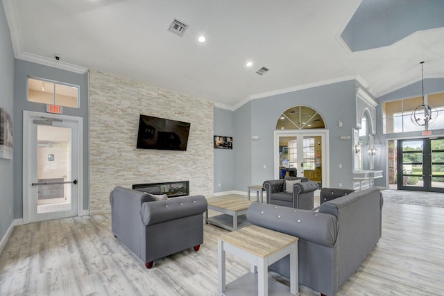 living room featuring french doors, ornamental molding, high vaulted ceiling, light hardwood / wood-style flooring, and a stone fireplace