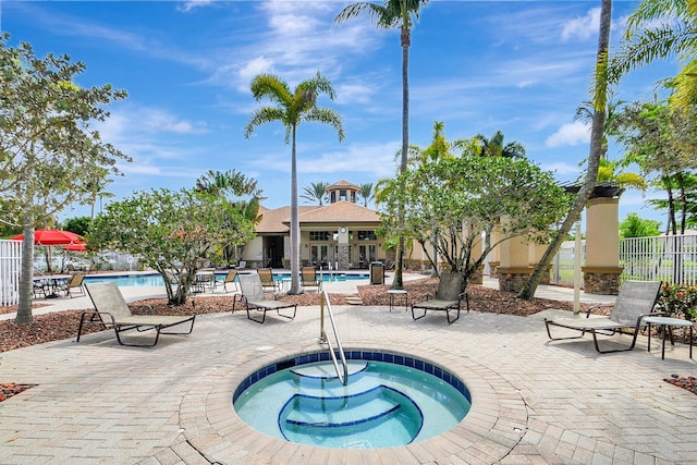 view of swimming pool featuring a patio area and a hot tub