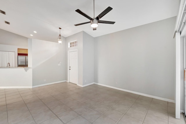 tiled empty room featuring ceiling fan and lofted ceiling