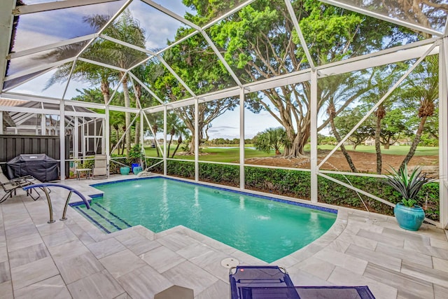 view of pool featuring a patio, glass enclosure, and area for grilling