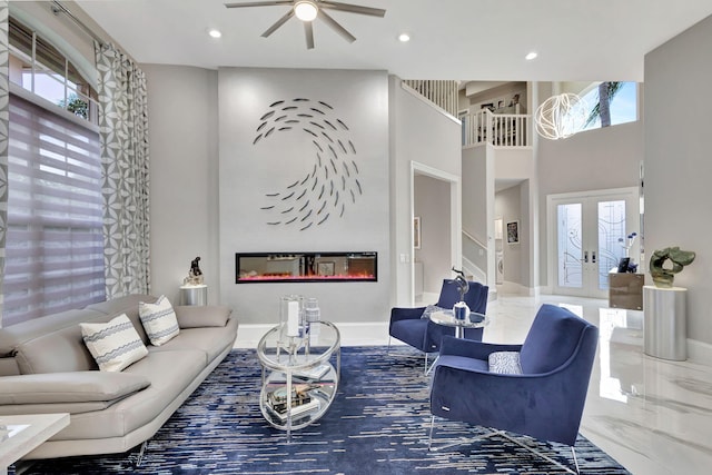 living room with ceiling fan, french doors, and a high ceiling