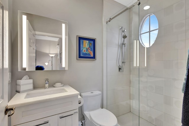 bathroom with an enclosed shower, vanity, and toilet