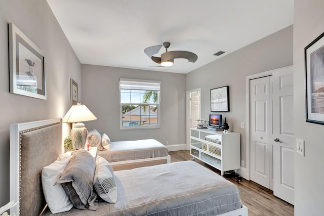 bedroom with a closet, hardwood / wood-style flooring, and ceiling fan