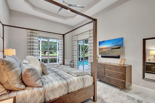 bedroom featuring a raised ceiling and access to exterior