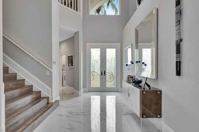 entrance foyer featuring washer / clothes dryer, a high ceiling, and french doors