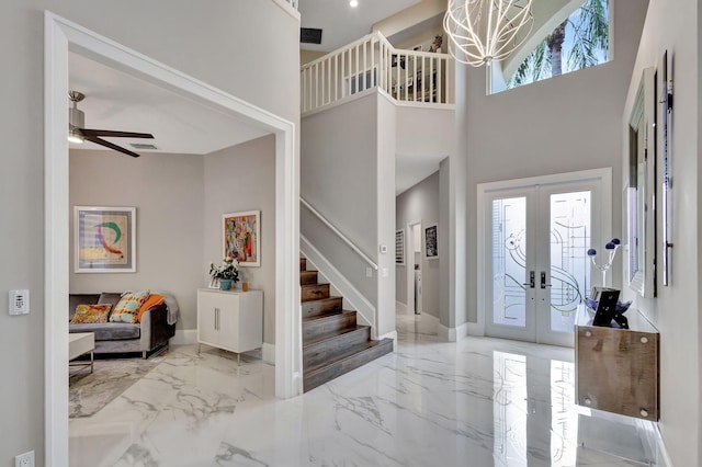 entryway with ceiling fan, a high ceiling, and french doors