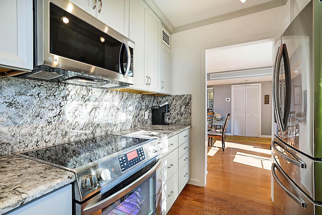 kitchen featuring white cabinets, light stone countertops, stainless steel appliances, and dark hardwood / wood-style floors