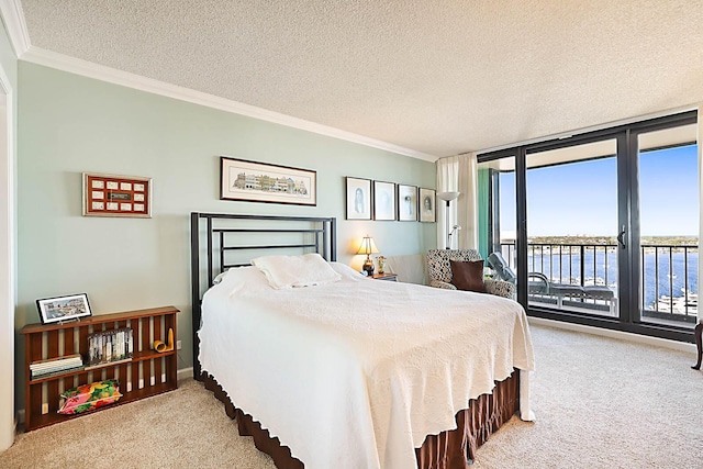 carpeted bedroom featuring access to exterior, ornamental molding, a textured ceiling, a water view, and a wall of windows