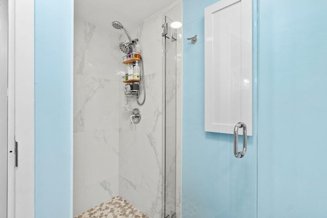 bathroom featuring a marble finish shower