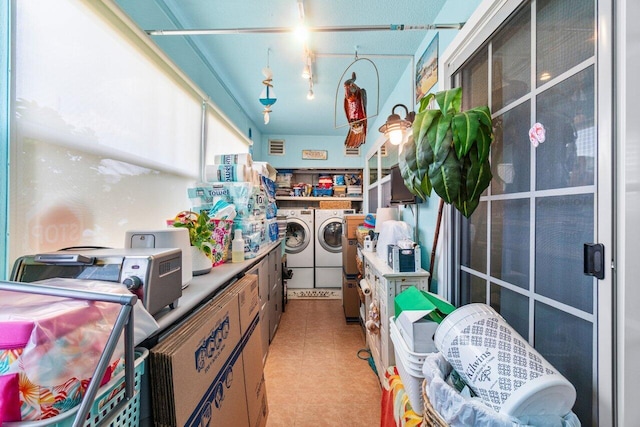 interior space with rail lighting and washing machine and clothes dryer