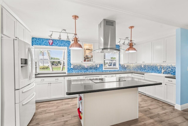 kitchen with light wood-type flooring, black electric stovetop, white fridge with ice dispenser, and island exhaust hood