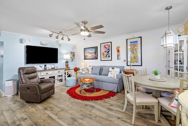 living room with light wood-type flooring, ceiling fan, and crown molding