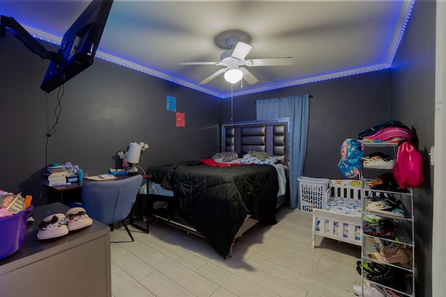 bedroom with light hardwood / wood-style flooring, ceiling fan, and crown molding