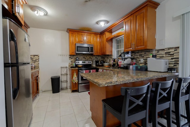 kitchen featuring kitchen peninsula, a breakfast bar, and stainless steel appliances