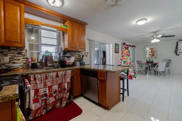 kitchen with dishwasher, decorative backsplash, kitchen peninsula, and dark stone countertops