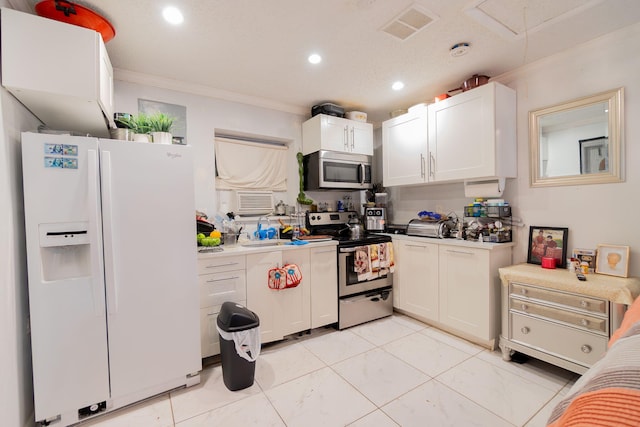 kitchen with white cabinets, ornamental molding, stainless steel appliances, and light tile patterned floors