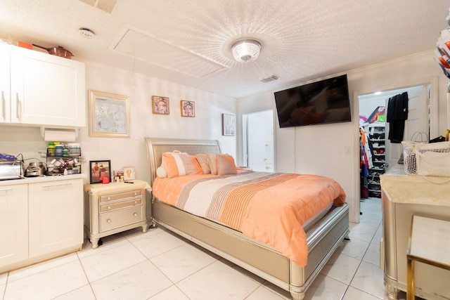 bedroom featuring a textured ceiling, a closet, and light tile patterned flooring