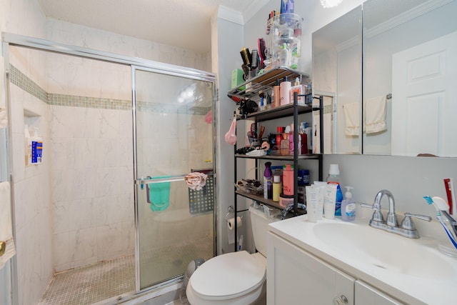 bathroom with vanity, toilet, a shower with shower door, and crown molding