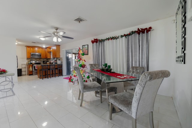 dining area with ceiling fan and light tile patterned flooring