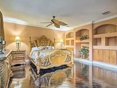 bedroom featuring hardwood / wood-style flooring, ceiling fan, and ornamental molding