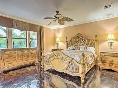 bedroom with wood-type flooring, ceiling fan, and ornamental molding