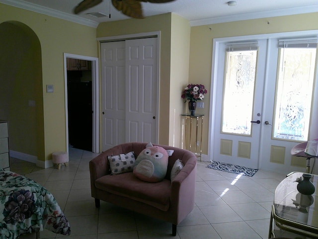 bedroom with ceiling fan, light tile patterned floors, crown molding, and french doors