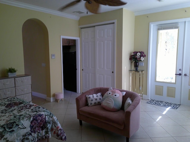 tiled bedroom featuring ceiling fan and crown molding