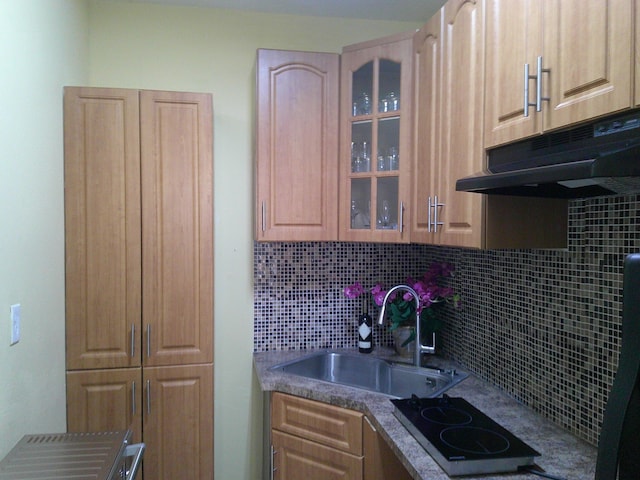 kitchen featuring cooktop, decorative backsplash, sink, and light brown cabinets