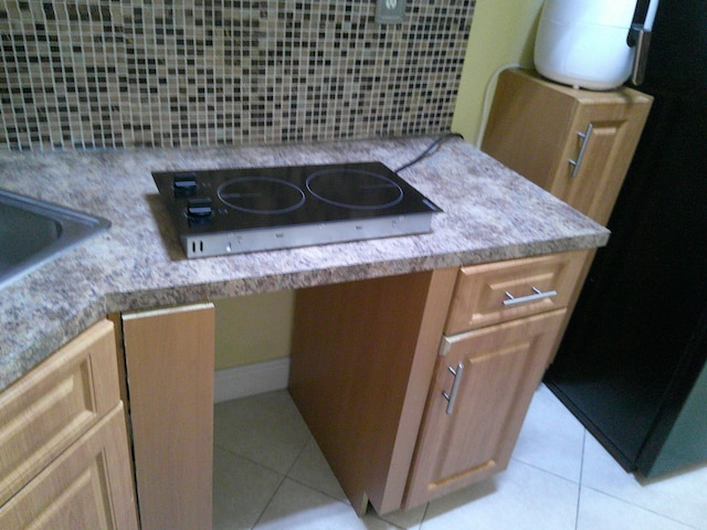 room details featuring black refrigerator and cooktop