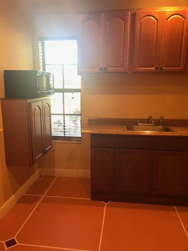 kitchen featuring light tile patterned floors and sink