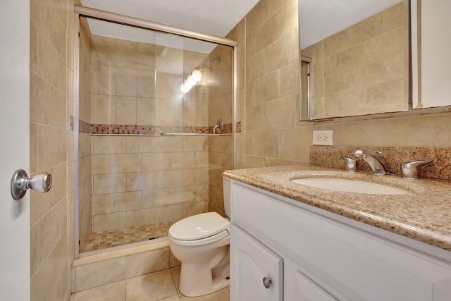 bathroom featuring tile patterned flooring, vanity, tile walls, and walk in shower