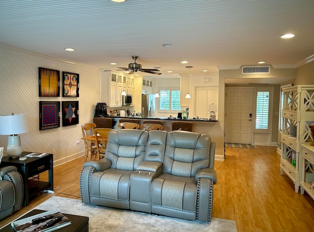 living room featuring light wood-type flooring, ceiling fan, and crown molding