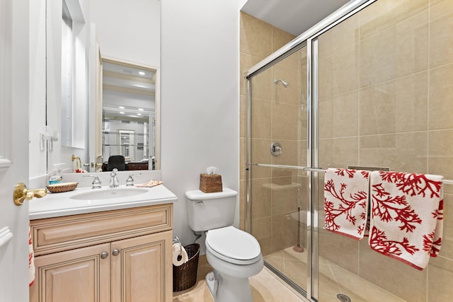 bathroom with tile patterned flooring, vanity, a shower with shower door, and toilet