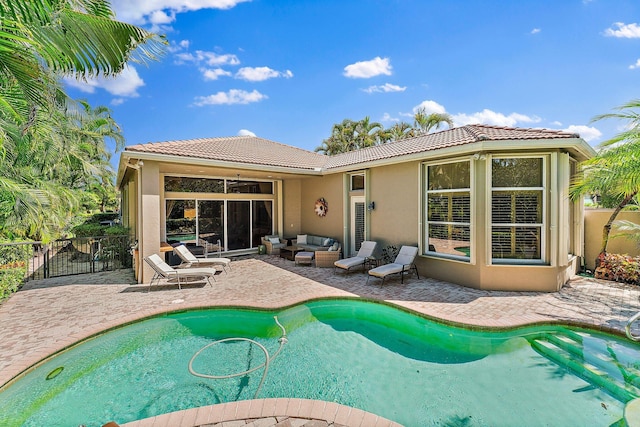 rear view of house featuring an outdoor living space, a patio, and a fenced in pool