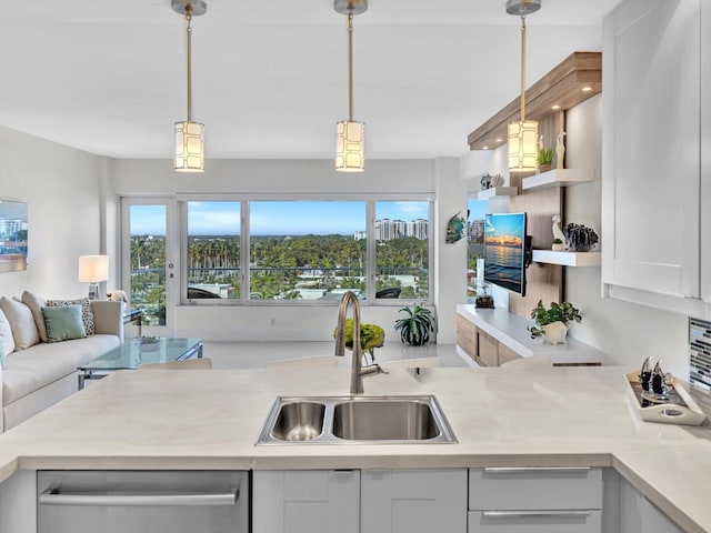 kitchen featuring dishwasher, sink, white cabinets, and pendant lighting