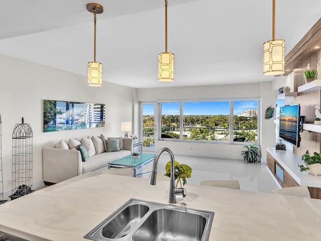 kitchen featuring decorative light fixtures, vaulted ceiling, and sink