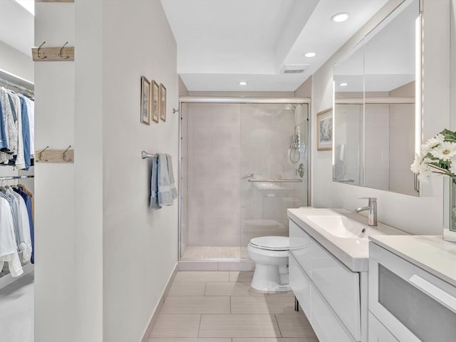 bathroom featuring tile patterned flooring, toilet, vanity, and walk in shower