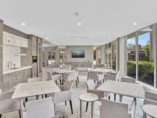 dining space with a wall of windows, plenty of natural light, and sink