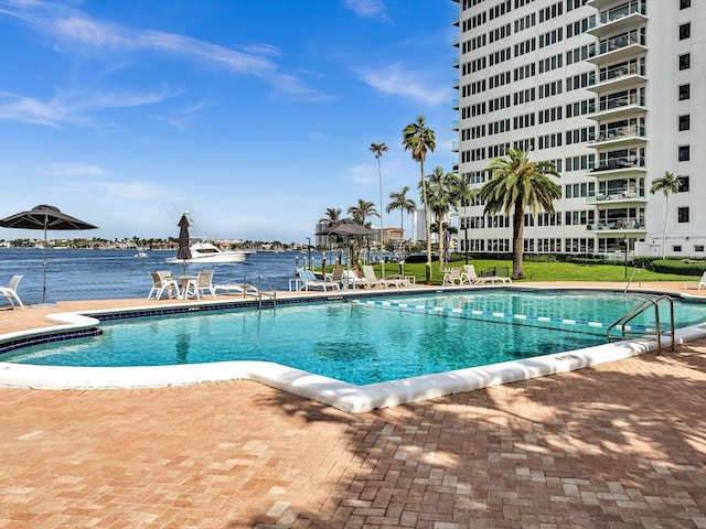 view of swimming pool with a water view and a patio