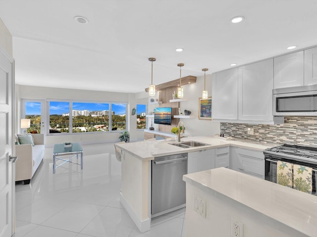 kitchen featuring decorative backsplash, white cabinetry, sink, and appliances with stainless steel finishes