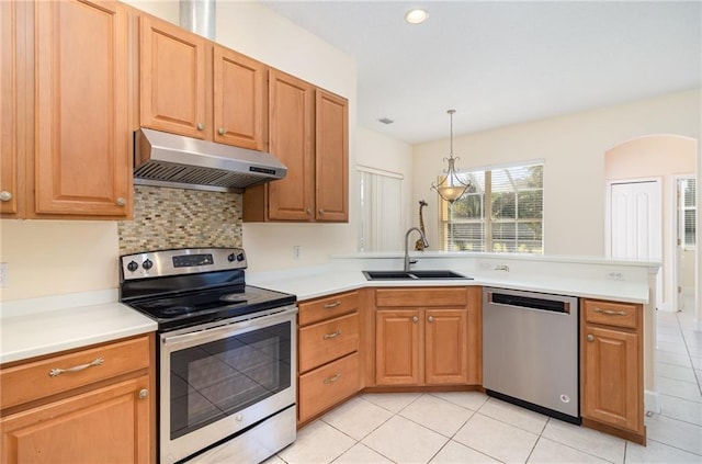 kitchen featuring light tile patterned floors, stainless steel appliances, hanging light fixtures, and sink