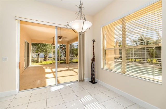 interior space with tile patterned flooring, ceiling fan, and a wealth of natural light