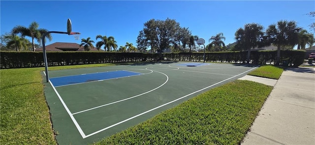 view of sport court with a lawn