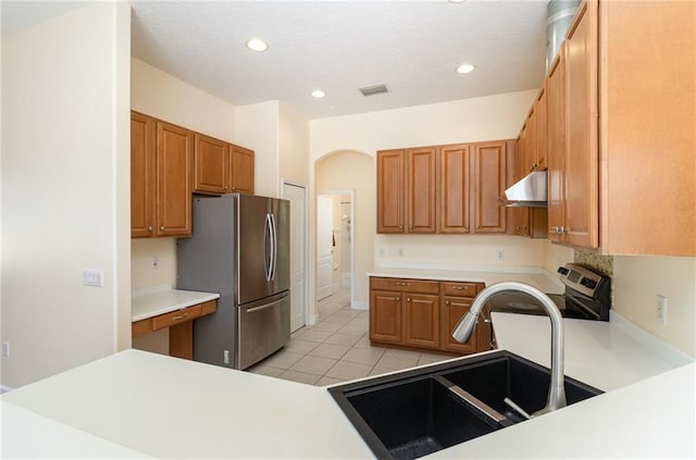 kitchen with appliances with stainless steel finishes, light tile patterned floors, and sink