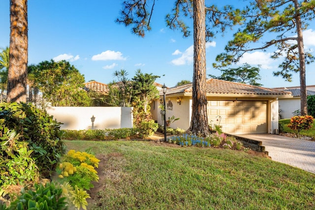 mediterranean / spanish-style home with a garage and a front lawn